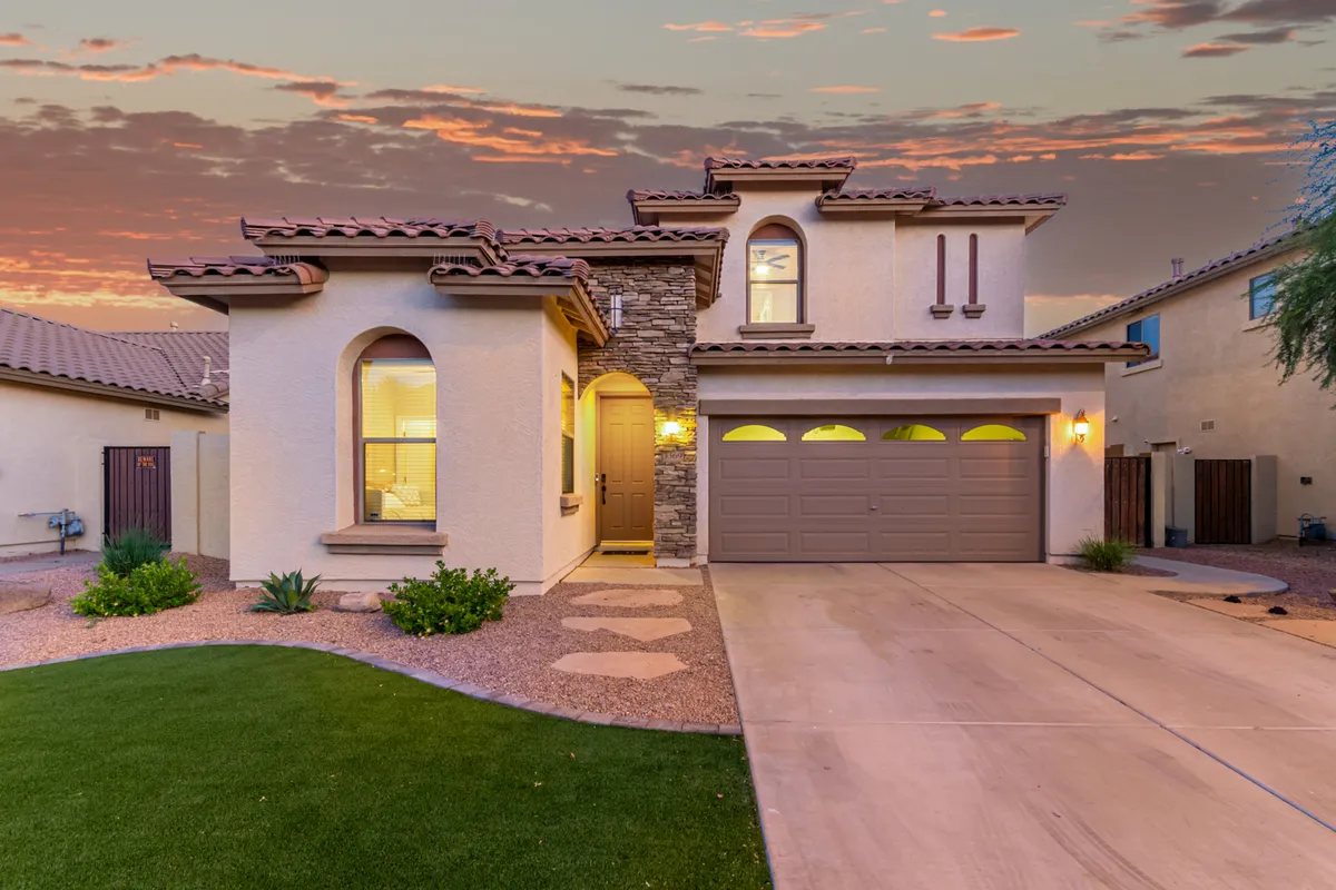 A welcoming exterior shot of the home's front entrance framed by stone accents and a landscaped yard. The mood is inviting, hinting at a peaceful neighborhood and the promise of family gatherings or tranquil mornings.